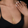 The Tower tarot cardboho chic pendant necklace , depicted in a striking gold color features a tall, imposing structure being struck by highlighting the crumbling tower as it tilts precariously. Two figures are shown falling from the structure, symbolizing sudden upheaval or chaos. The background is often minimal, allowing the vivid gold tones to emphasize the tower's destruction and the sense of unexpected change or revelation it represents.