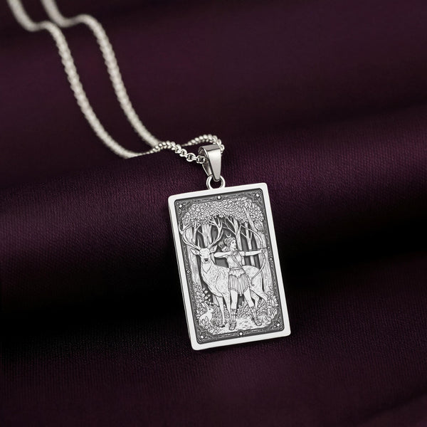 A striking 925 sterling silver tarot card pendant of the Goddess of the Hunt, Artemis. This piece of witchy jewelry is styled on a dark purple silk background.