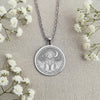 A handcrafted 925 sterling silver Portie charm in a round medallion shape. This personalized piece of dog lover jewelry shows the curly haired breed in a magical celestial setting.