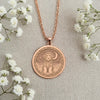 An elegant rose gold plated coin pendant celebrating a beloved canine companion. The engraved art shows a Portuguese Water Dog on a cloud, a beautiful piece of memorial jewelry.
