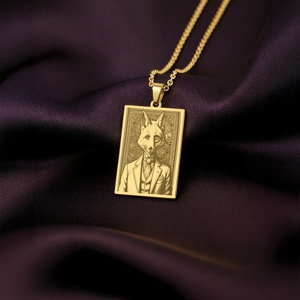 A handmade 14K gold plated rectangular necklace with a highly detailed engraving of a Victorian fox. The anthropomorphic art shows a cunning gentleman fox in a dapper suit from the Victorian Pet collection.