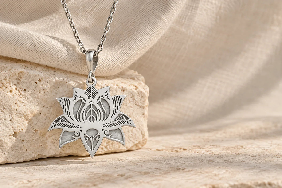 Silver lotus pendant on textured ivory fabric and pale stone