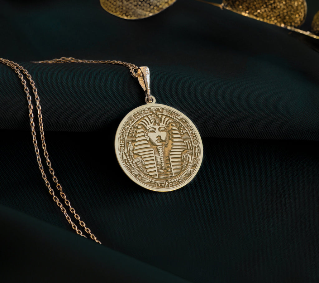 14k solid yellow gold Tutankhamun coin pendant, real gold charm representing Egyptian royalty. Lightweight and versatile, ideal for layering or solo wear. This unique amulet is a meaningful gift, blending mystique and minimalist elegance.