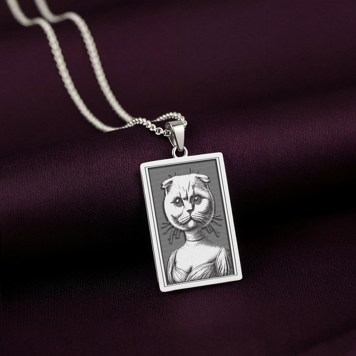 Front-facing view of the 925 Sterling Silver Scottish Fold necklace, showcasing its bright, cool tone against the dark purple satin background.