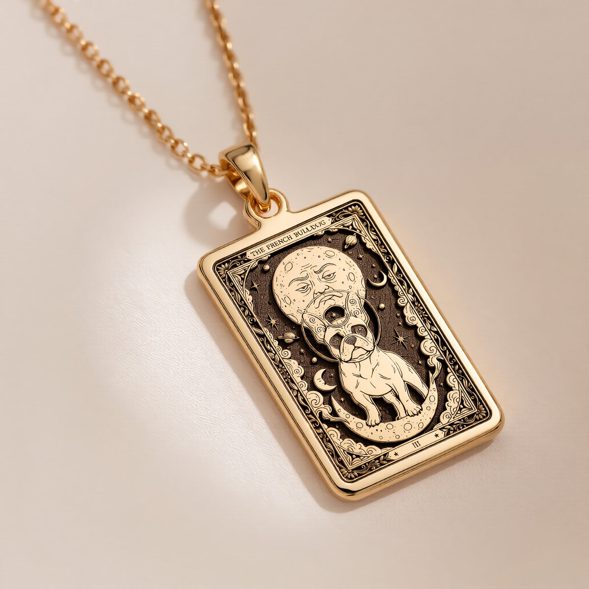 An heirloom-quality 14K solid gold French Bulldog tarot pendant. The art shows the Frenchie under a moon-face, symbolizing its comical spirit, a precious dog mom gift.