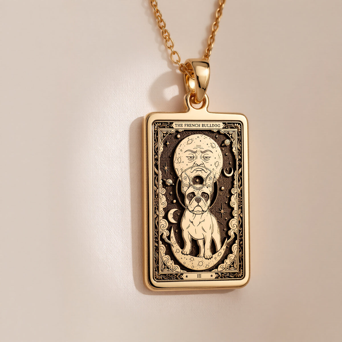 An heirloom-quality 14K solid gold French Bulldog tarot pendant. The art shows the Frenchie under a moon-face, symbolizing its comical spirit, a precious dog mom gift.