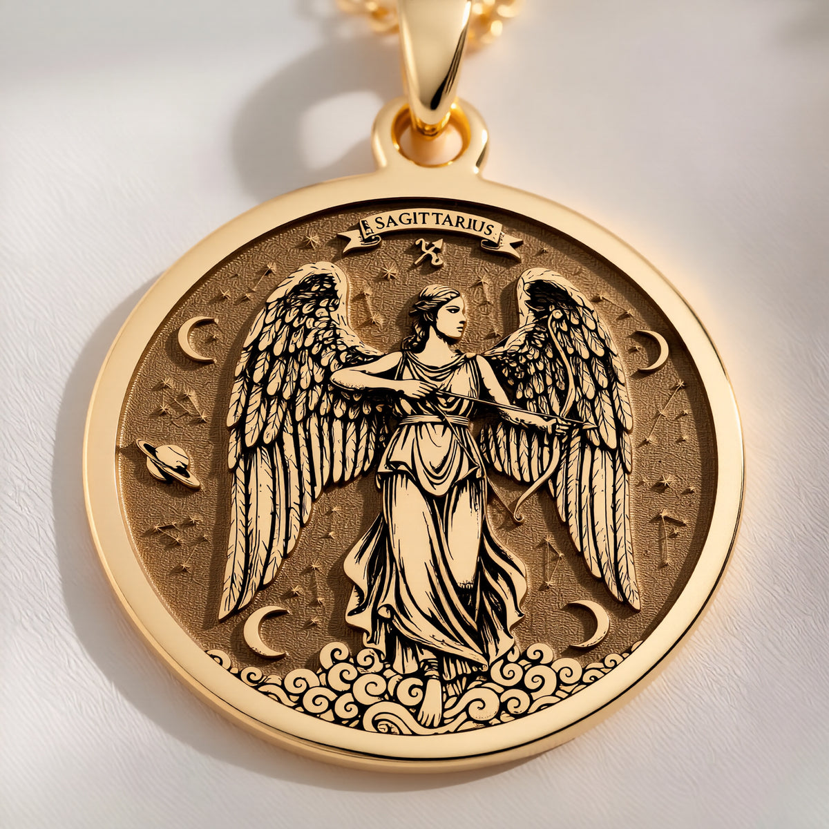 Macro detail of the 14K solid gold Sagittarius angel medallion showing feathered wings, bow, crescent moon, and stars.