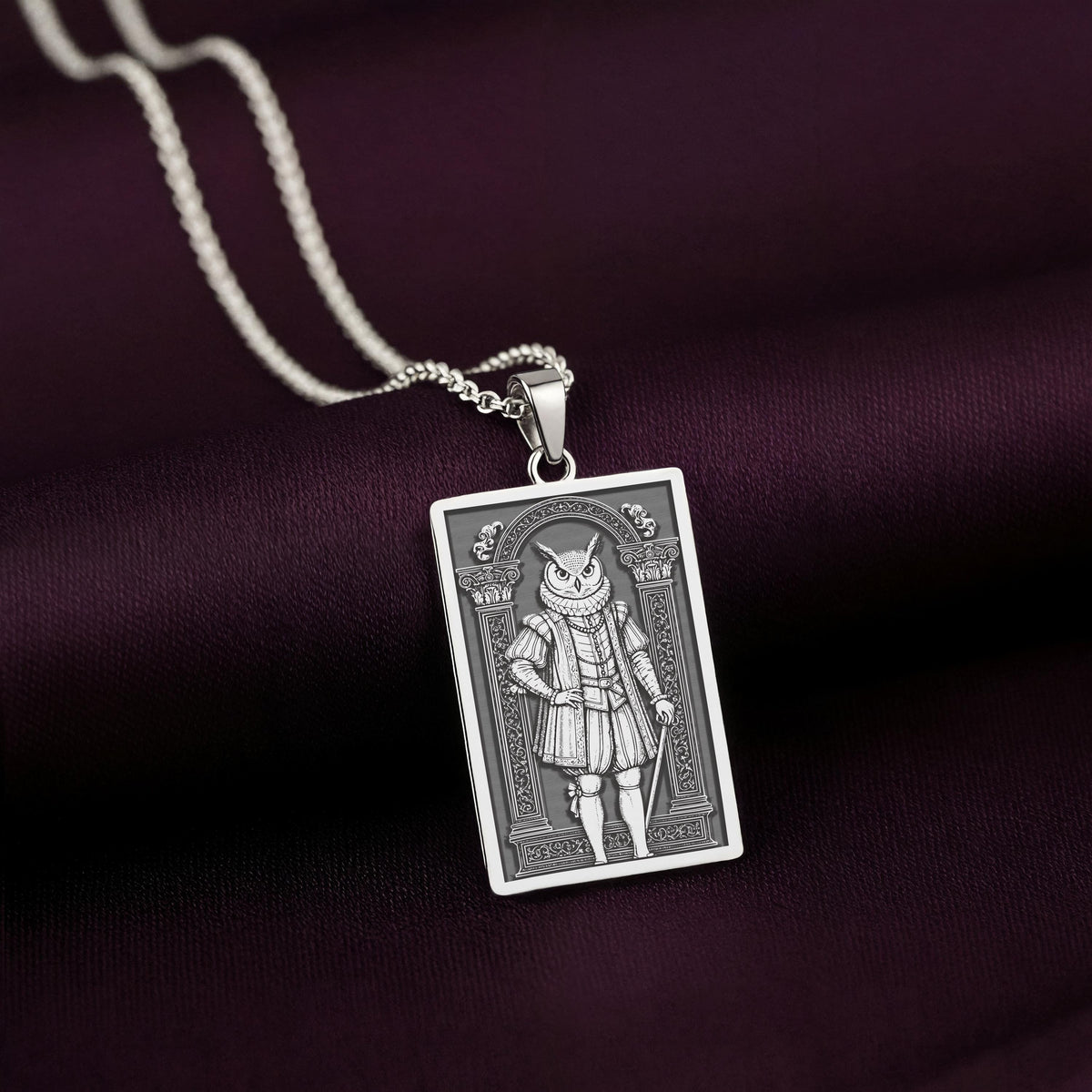 A handcrafted 925 sterling silver wise owl charm in a rectangular shape. This personalized piece of anthropomorphic jewelry is a standout accessory for any admirer of the symbol of wisdom.