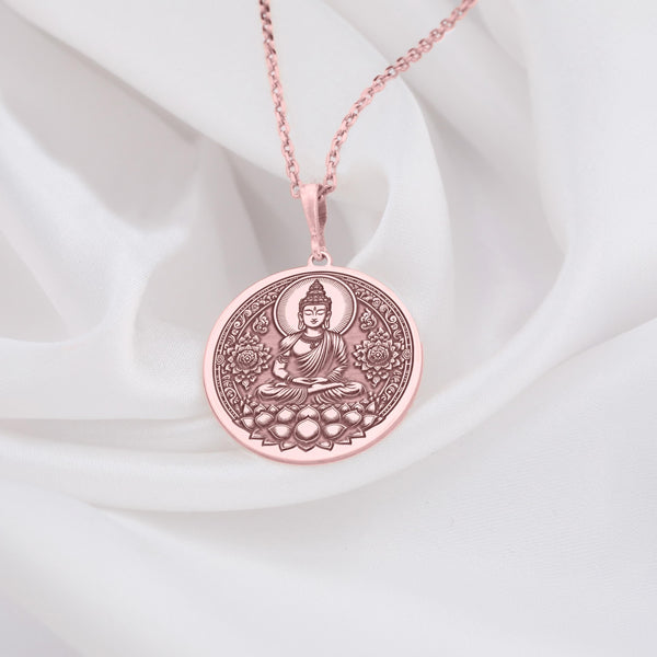 Buddha figure seated in meditative lotus pose (Padmasana) upon a blooming lotus flower base. The trendy, warm pinkish hue of the durable rose gold plating [over Specify Base Metal if Known] enhances the detailed artistry of the central deity and the surrounding ornate floral mandala-style patterns filling the circular frame.Perfect yoga or mindfulness fashion jewelry gift.