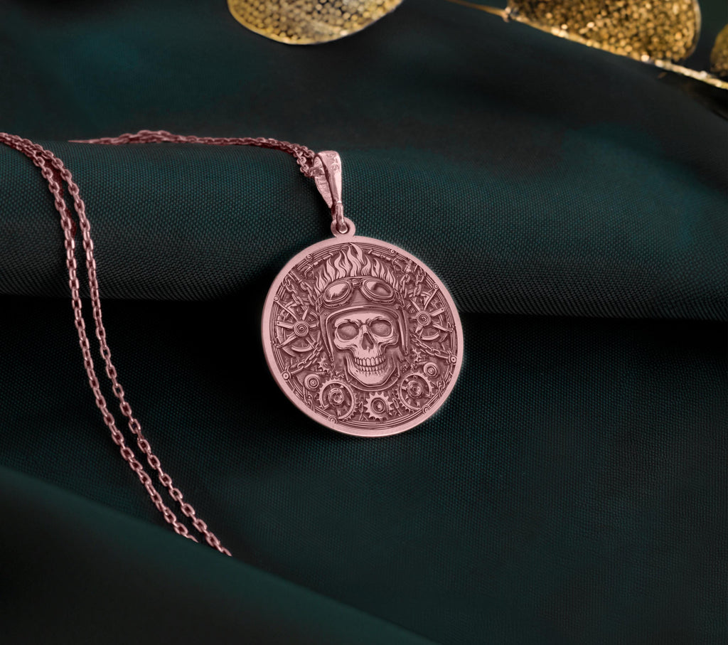 Rose Gold Plated Biker Skull Pendant with mechanical gear design. Warm-toned aviator medallion with detailed helmet, goggles and industrial background. Alternative jewelry celebrating road freedom, perfect for motorcycle riders and rebels.