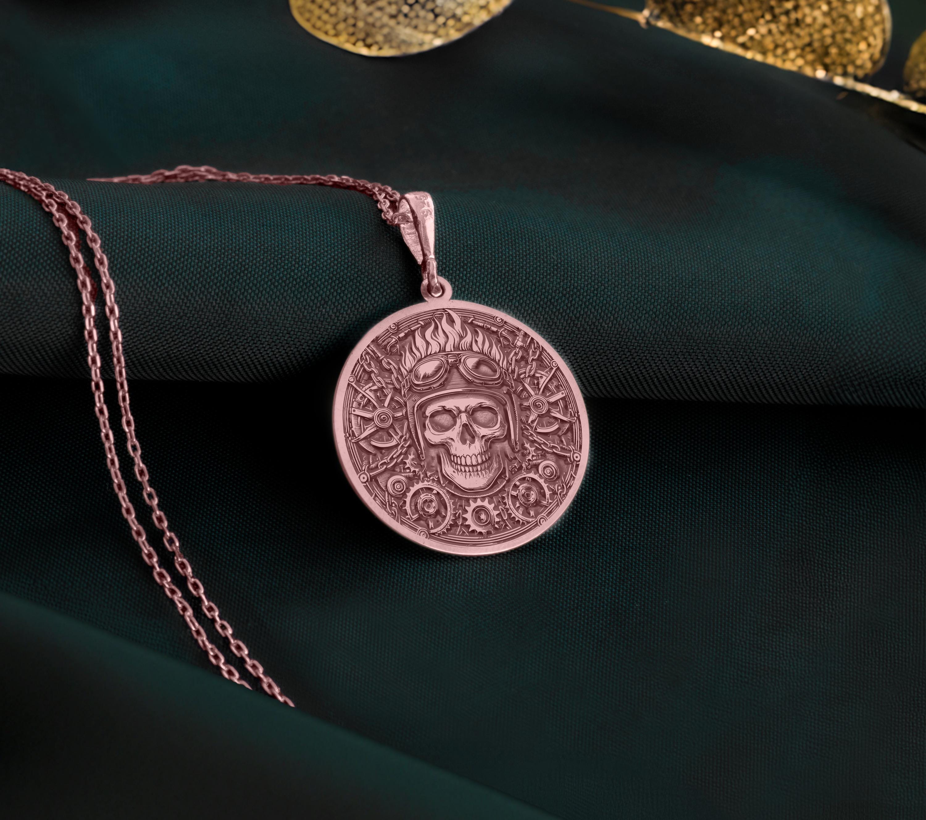 Rose Gold Plated Biker Skull Pendant with mechanical gear design. Warm-toned aviator medallion with detailed helmet, goggles and industrial background. Alternative jewelry celebrating road freedom, perfect for motorcycle riders and rebels.