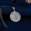 Sterling silver Durga pendant necklace showcasing the revered Hindu goddess seated on her tiger vahana. This detailed circular medallion captures Durga with multiple arms holding symbolic weapons and objects. The pendant features meticulous engravings with an oxidized finish to highlight the intricate details of the goddess and her tiger mount. Displayed on white silk fabric with a matching silver chain, this spiritual jewelry piece symbolizes feminine strength, protection against evil