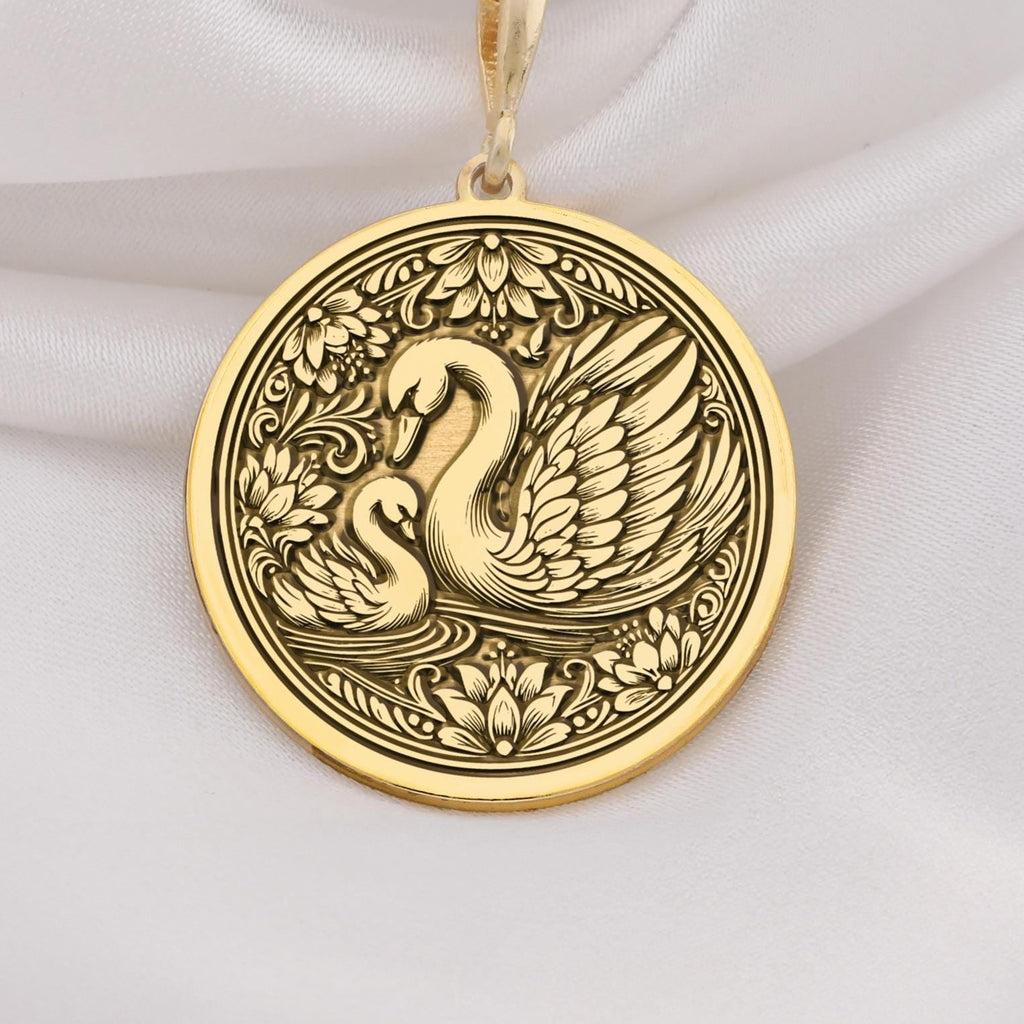 14K Solid Gold Mother Baby Swan Medallion featuring protective mother swan with baby cygnet surrounded by ornate decorative elements. Detailed maternal talisman with family bond symbolism. Luxury swan family jewelry representing unconditional love.