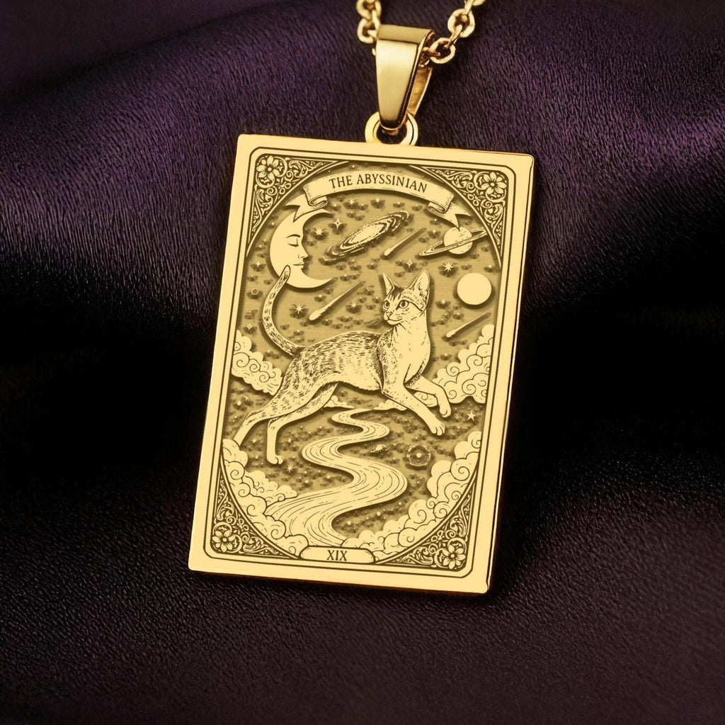 An heirloom-quality 14K solid gold Abyssinian Cat tarot pendant. The art shows the sleek cat leaping, a precious gift for a cat lover.