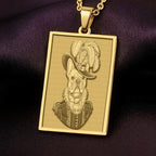 Product photo of a 14K Solid Gold French Bulldog necklace from 'The Ancestors Collection'. The rectangular pendant features an engraved dog in a plumed Renaissance hat, resting on rich purple satin.