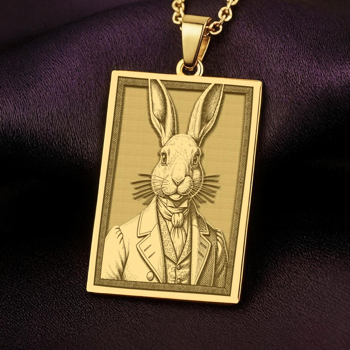 A handmade 14K gold plated rectangular necklace with a highly detailed engraving of a Victorian rabbit. The anthropomorphic art shows the gentleman bunny in a dapper suit.