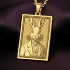 A handmade 14K gold plated rectangular necklace with a highly detailed engraving of a Victorian rabbit. The anthropomorphic art shows the gentleman bunny in a dapper suit.