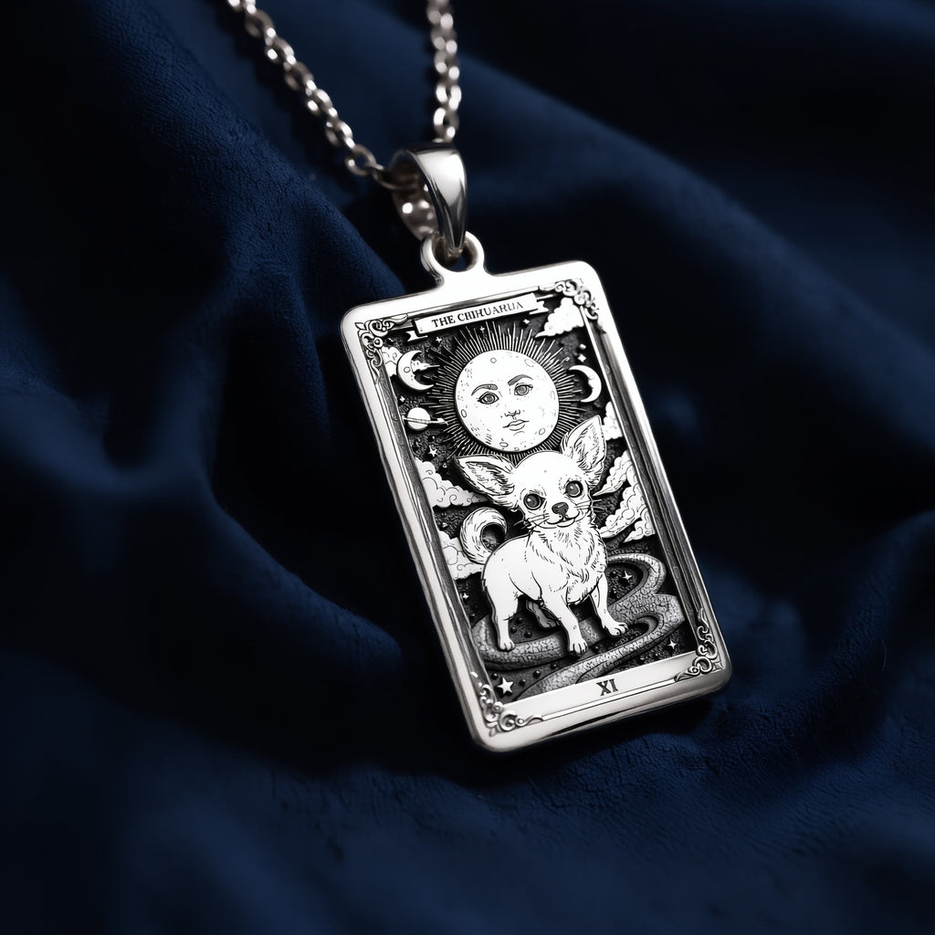 Rectangular sterling silver pendant featuring an engraved Chihuahua tarot card design with celestial moon, stars, and Roman numeral XI, displayed on a silver chain against dark blue fabric.