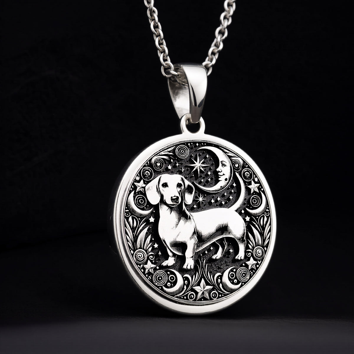 Sterling silver Dachshund pendant necklace, front view of round pendant with engraved dog beside crescent moon and stars.