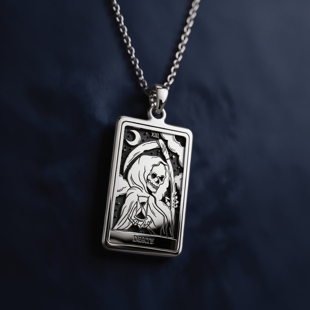 Rectangular silver pendant necklace featuring an engraved Death Tarot card design with a skeletal figure, hourglass, crescent moon, Roman numeral XIII, and “DEATH” inscription at the bottom.
