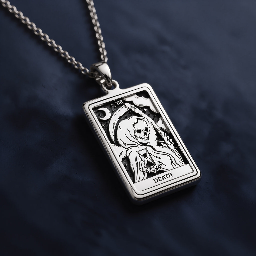 Rectangular silver pendant featuring the Death tarot card from the Rider Waite deck, engraved with a hooded skeletal figure holding an hourglass against a starry night background.