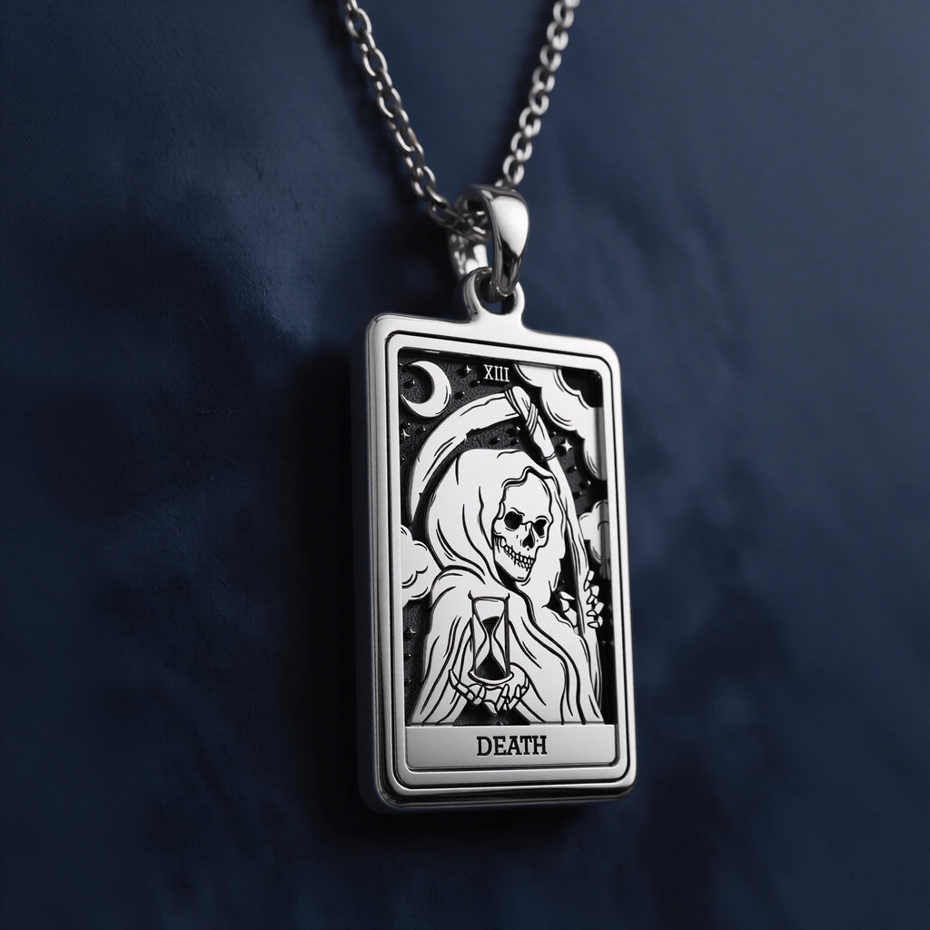 Rectangular silver pendant necklace featuring an engraved Death Tarot card design with a hooded skeletal figure, hourglass, crescent moon, Roman numeral XIII, and “DEATH” inscription at the bottom.