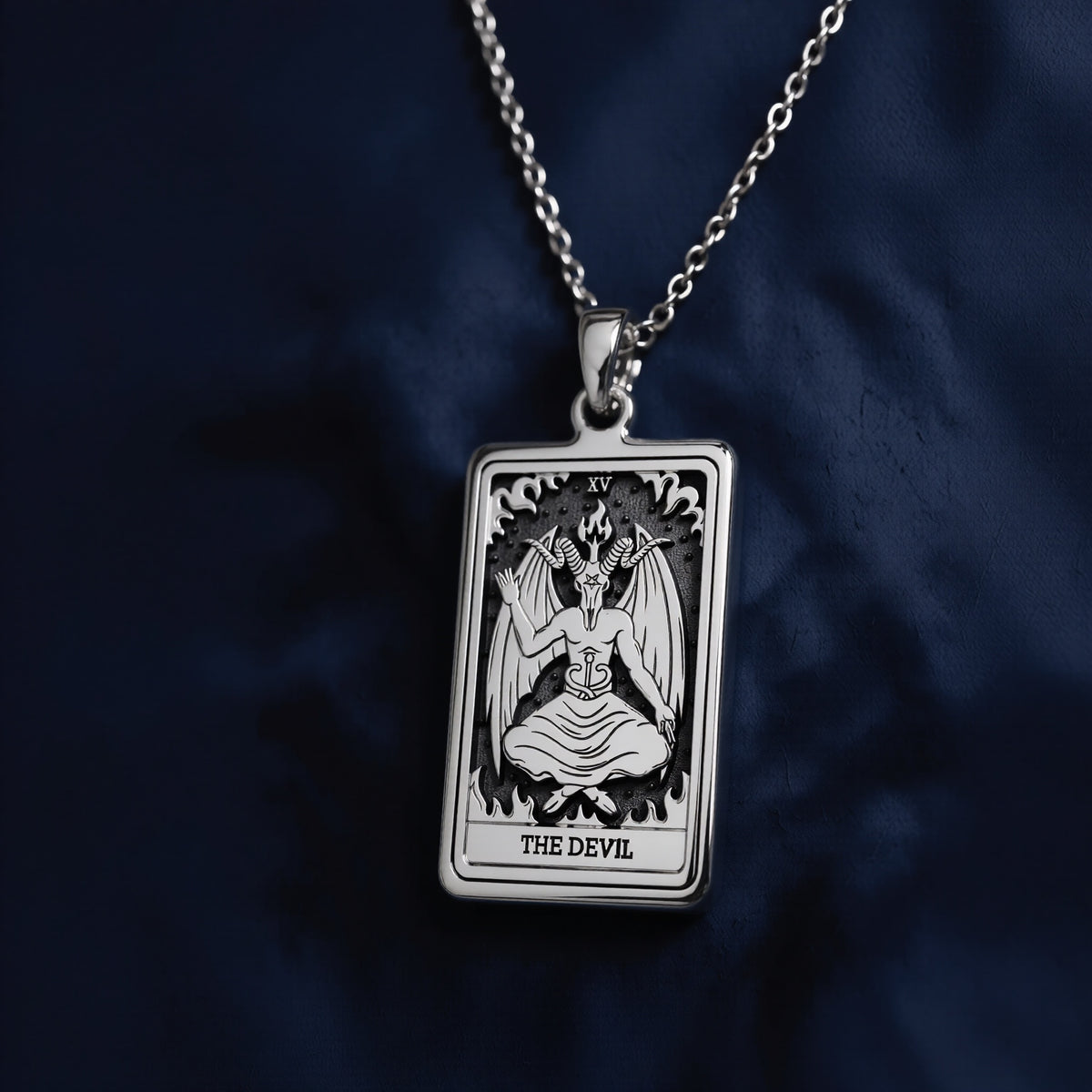 This rectangular pendant necklace features a detailed engraving of The Devil tarot card (XV) from the Rider Waite deck, showcasing a seated horned figure with wings against a dark background. Crafted in polished 925 sterling silver and suspended on a matching chain, it serves as an occult amulet for spiritual protection.