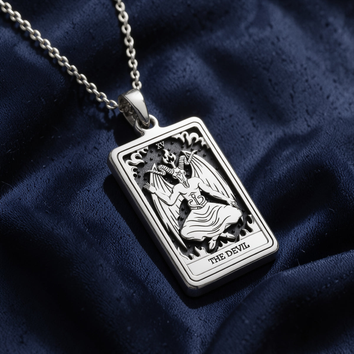 Rectangular sterling silver pendant necklace featuring an intricately engraved Rider Waite Tarot card design of The Devil, complete with Roman numeral XV, horned figure, wings, flames, and inscribed title.