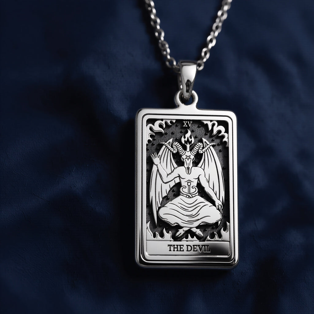 Rectangular silver pendant featuring an intricately engraved Rider Waite Tarot card of The Devil (XV), showcasing a seated horned figure with wings, flames, and the inscription "THE DEVIL" at the bottom.