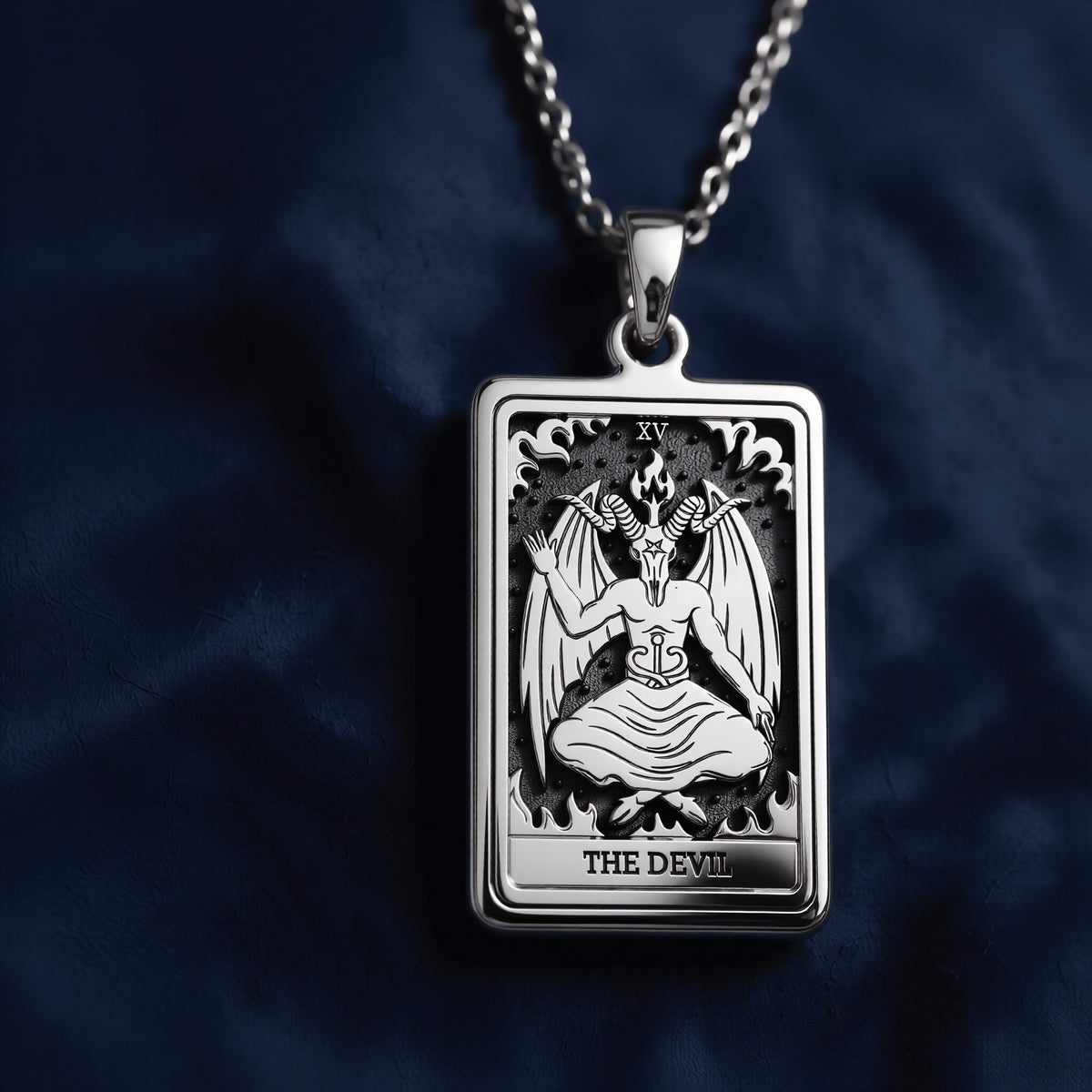 Rectangular silver pendant featuring an intricately engraved Rider Waite Tarot card of The Devil (XV), showcasing a seated horned figure with wings, flames, and the inscription "THE DEVIL" at the bottom.