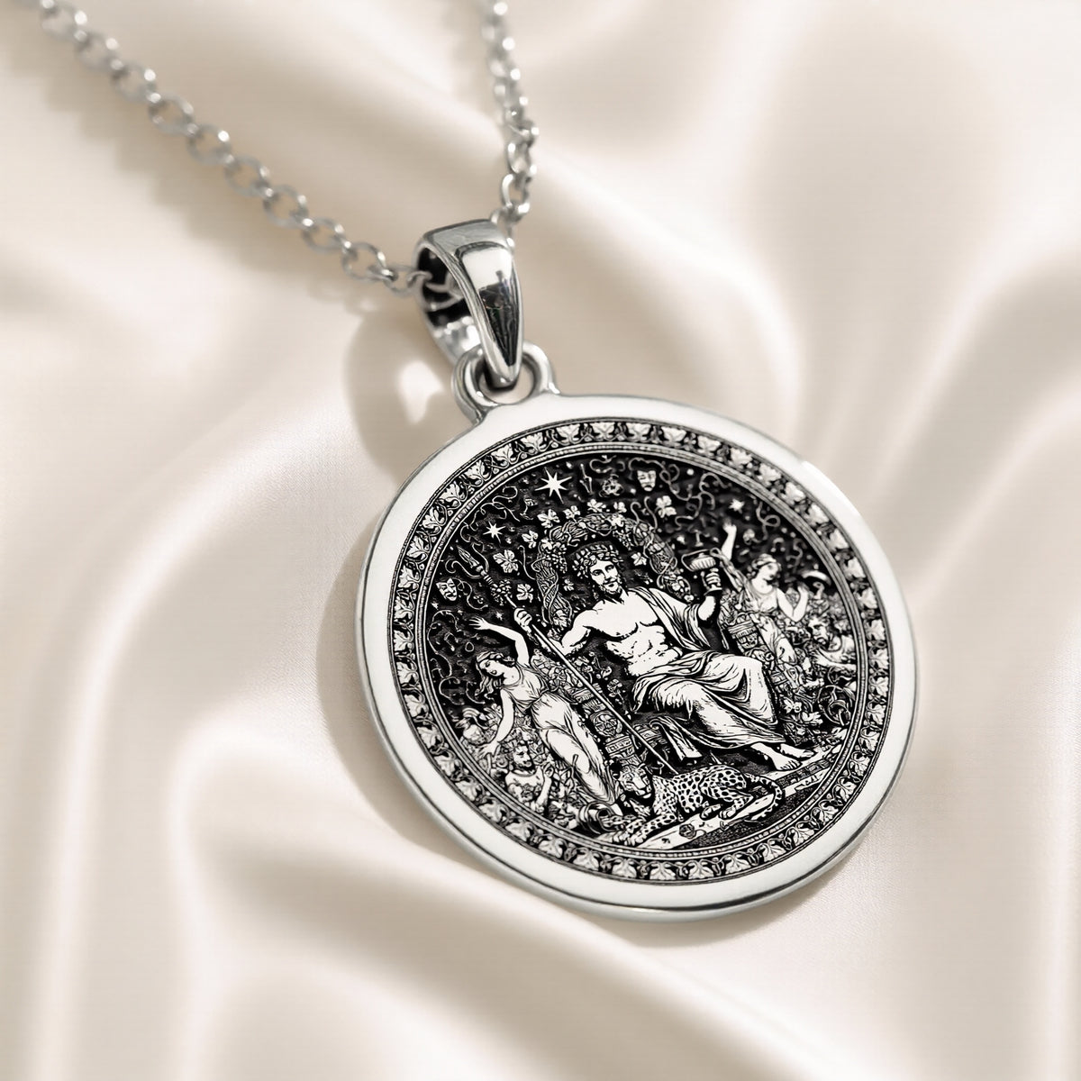 Silver circular pendant featuring a detailed classical scene with figures, presented in a silver tone. The pendant hangs from a silver chain and is viewed from the front.