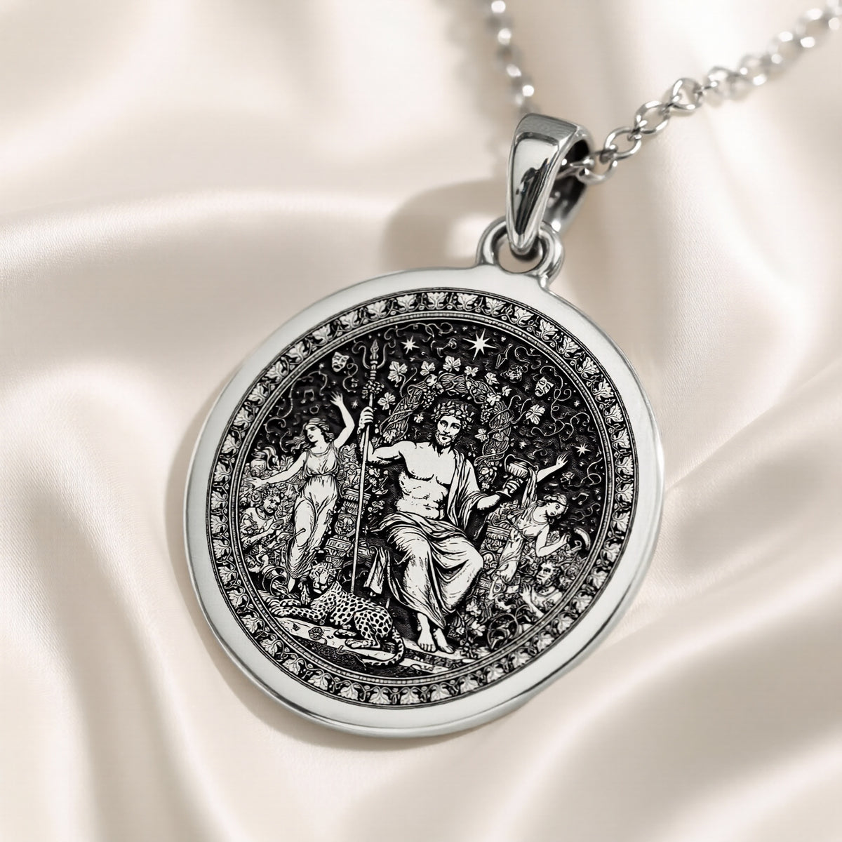 Silver circular pendant featuring a detailed classical scene with figures, presented in a silver tone. The pendant hangs from a silver chain and is viewed from the front.