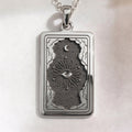 Eye Tarot Necklace pendant in sterling silver: front view of rectangular medallion featuring an all-seeing eye surrounded by stars, a crescent moon, and cloud motifs.