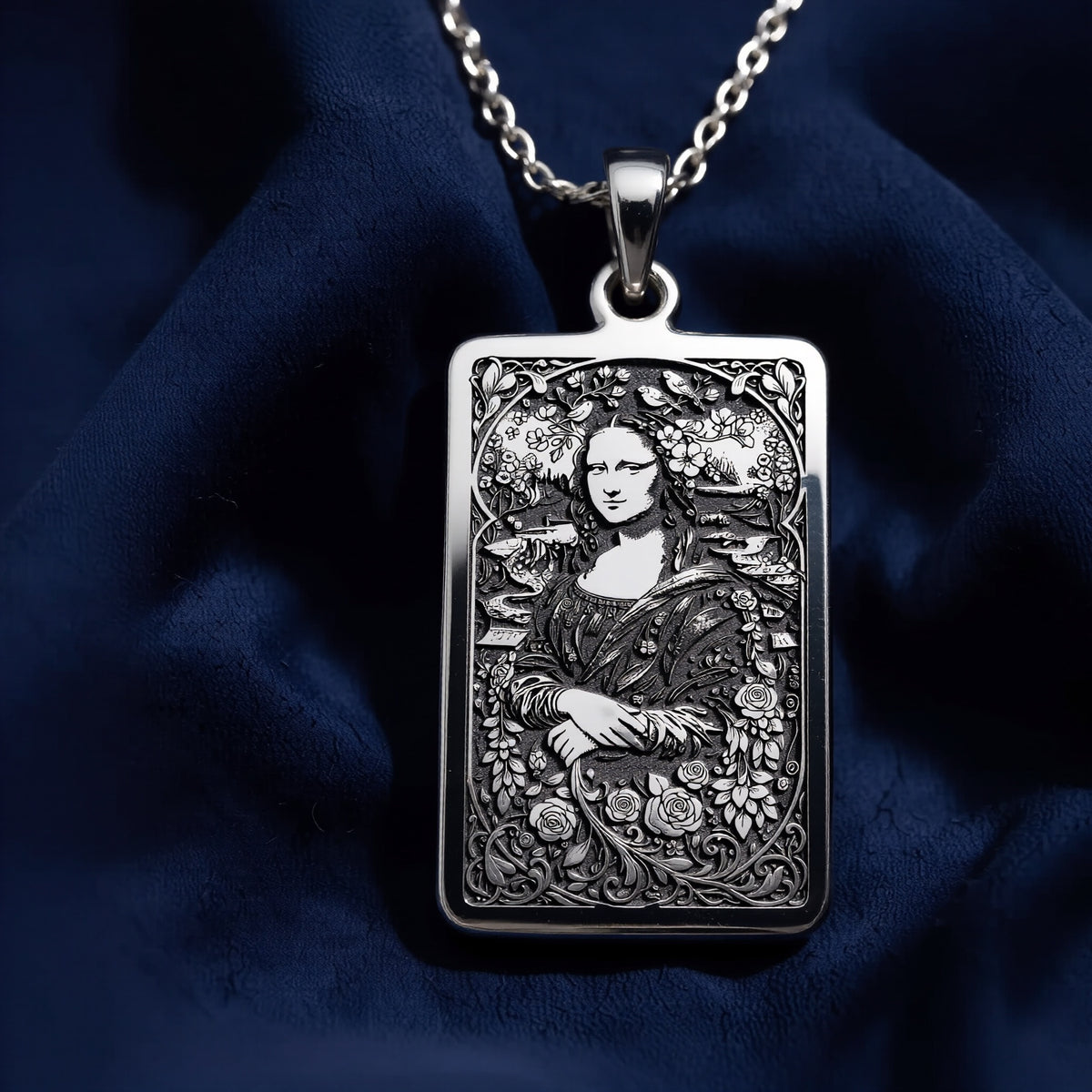 Silver pendant featuring a detailed Mona Lisa Tarot card design with intricate line work and shading. The pendant has a polished, reflective surface finish. It is displayed on a black background with a delicate chain visible.