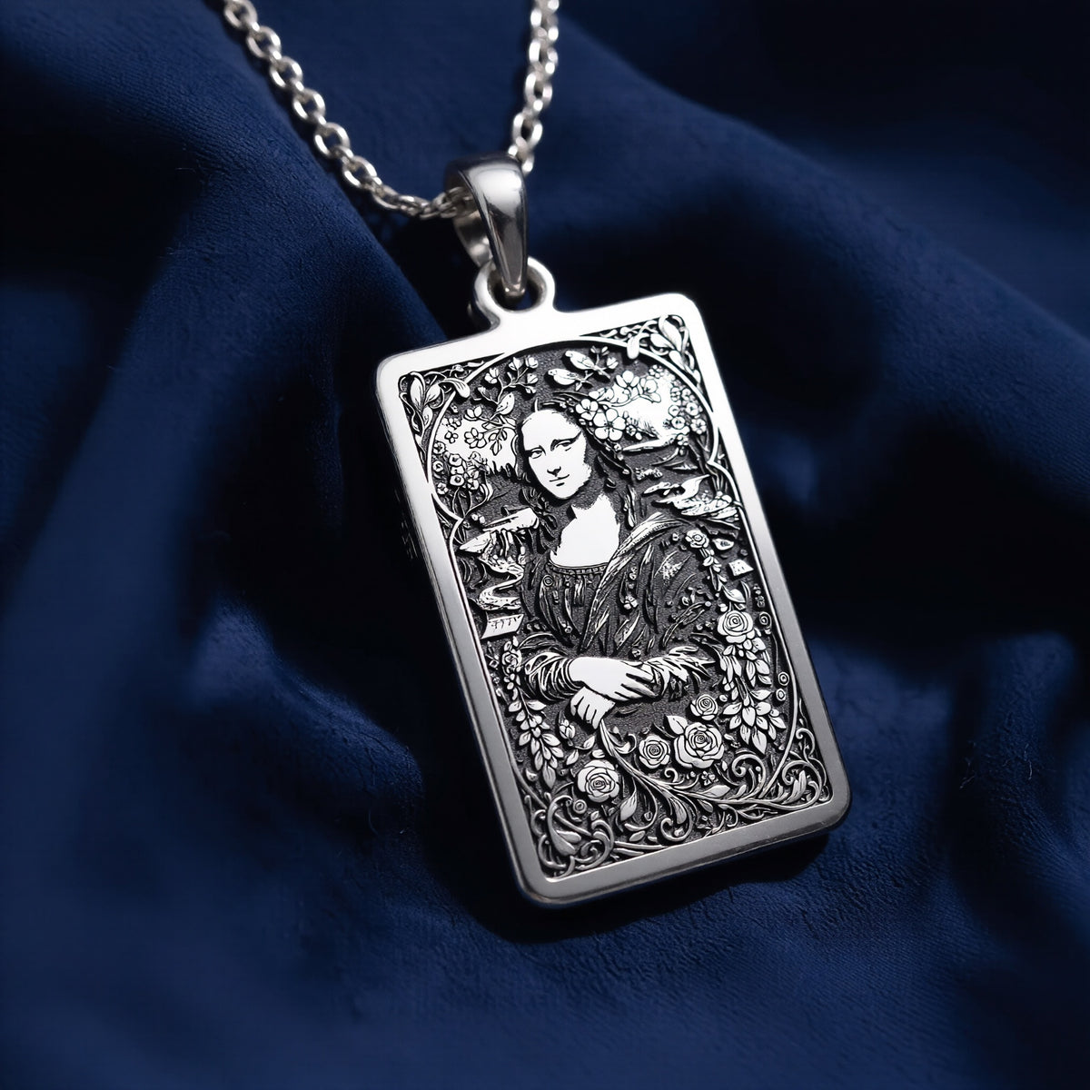Silver pendant featuring a detailed outline of the Mona Lisa, antique style, with an intricate filigree design. The pendant has a textured surface finish and is suspended from a delicate chain.