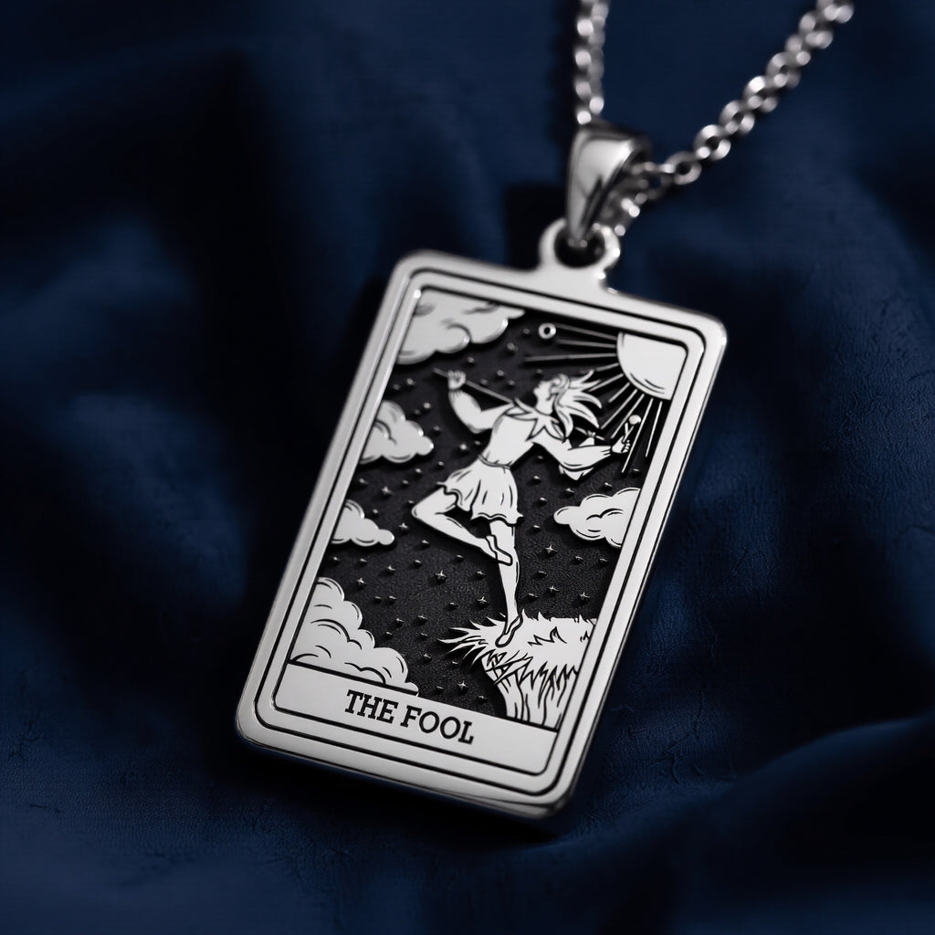 Rectangular 925 sterling silver pendant necklace featuring an engraved Major Arcana "The Fool" tarot card design with a leaping figure, clouds, stars, and sunburst detail on a dark oxidized background.
