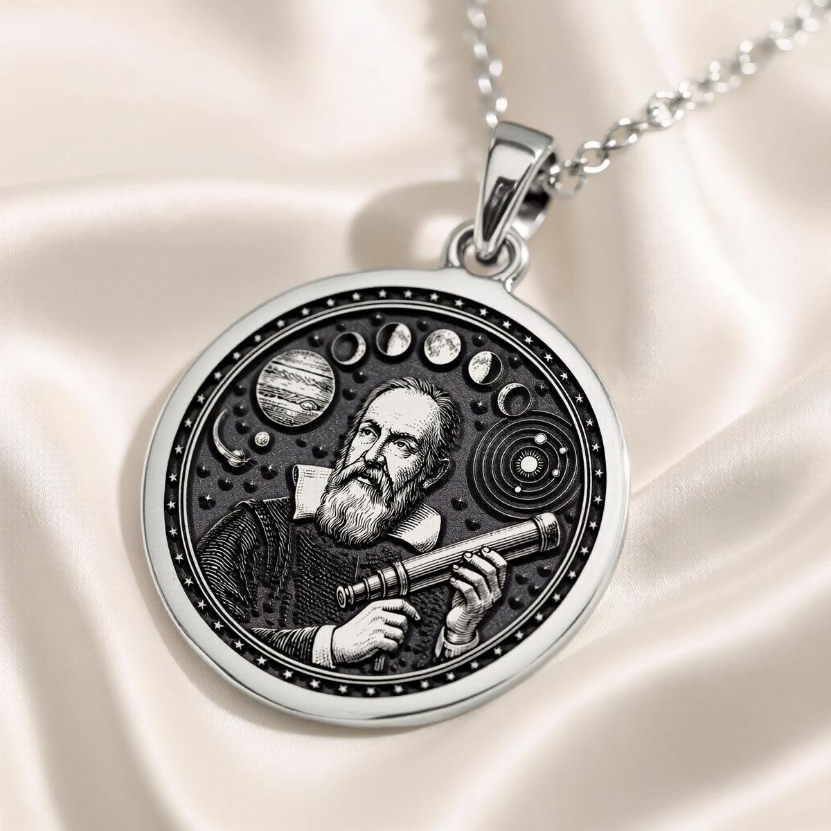 Silver pendant with an engraved circular design featuring an astronomical motif, viewed from above on a velvet surface