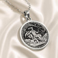 Silver plated circular pendant featuring an engraved design of the Messenger God Hermes. This piece is attached to a silver chain and set against a deep blue background fabric.