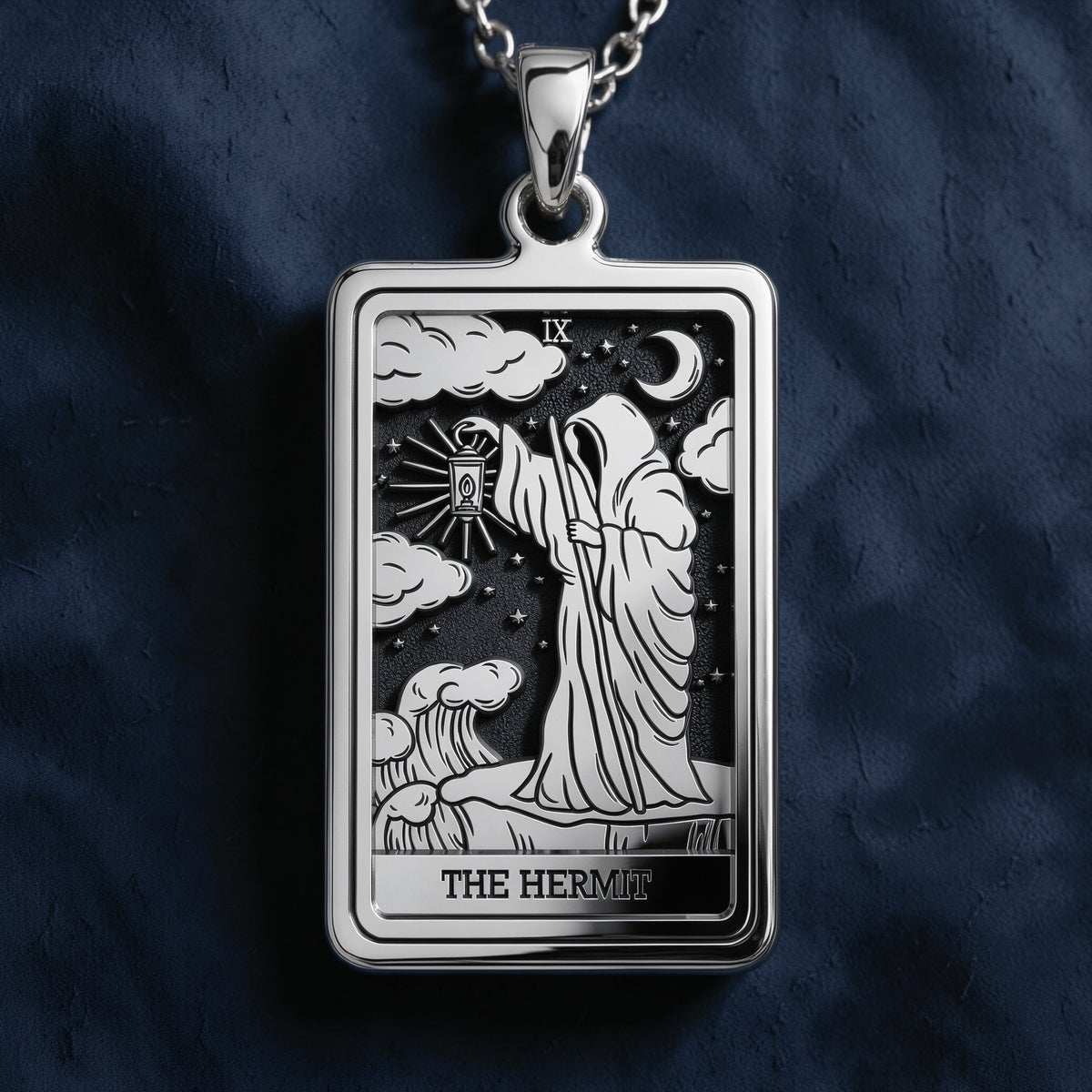 Rectangular sterling silver pendant featuring a detailed engraving of The Hermit tarot card, depicting a robed figure holding a lantern under a starry night sky with clouds and crescent moon.