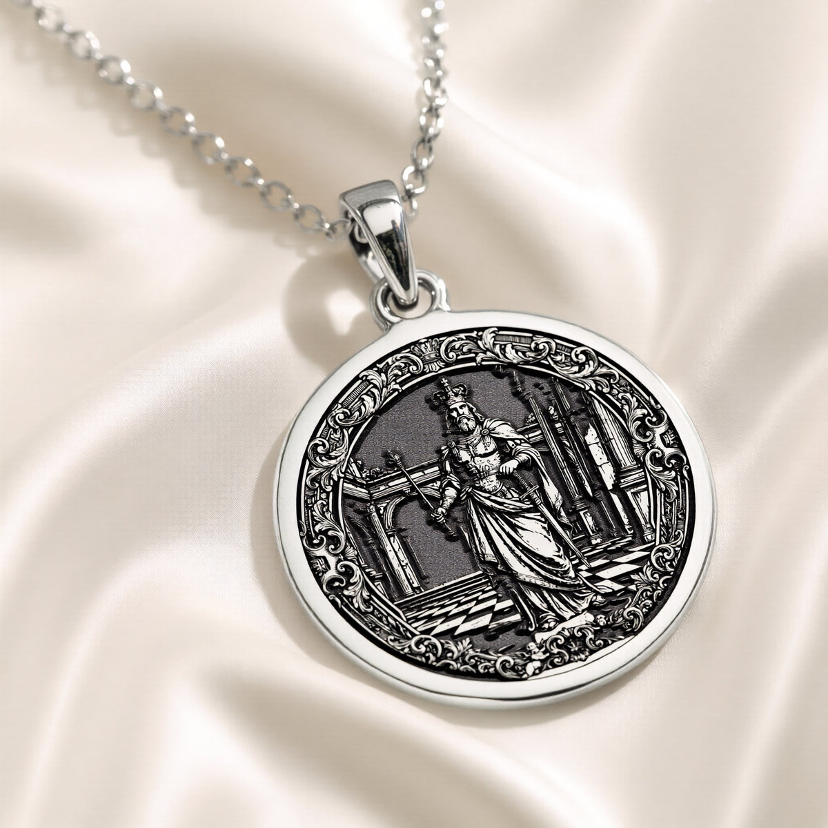 Silver pendant featuring a circular design of a king chess motif with an intricate surface finish, shown from a close-up view on a velvet background