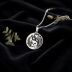 Koi Fish Talisman Necklace Necklaces 925 925 Sterling Silver dragon coiled pendant necklace on black fabric.
