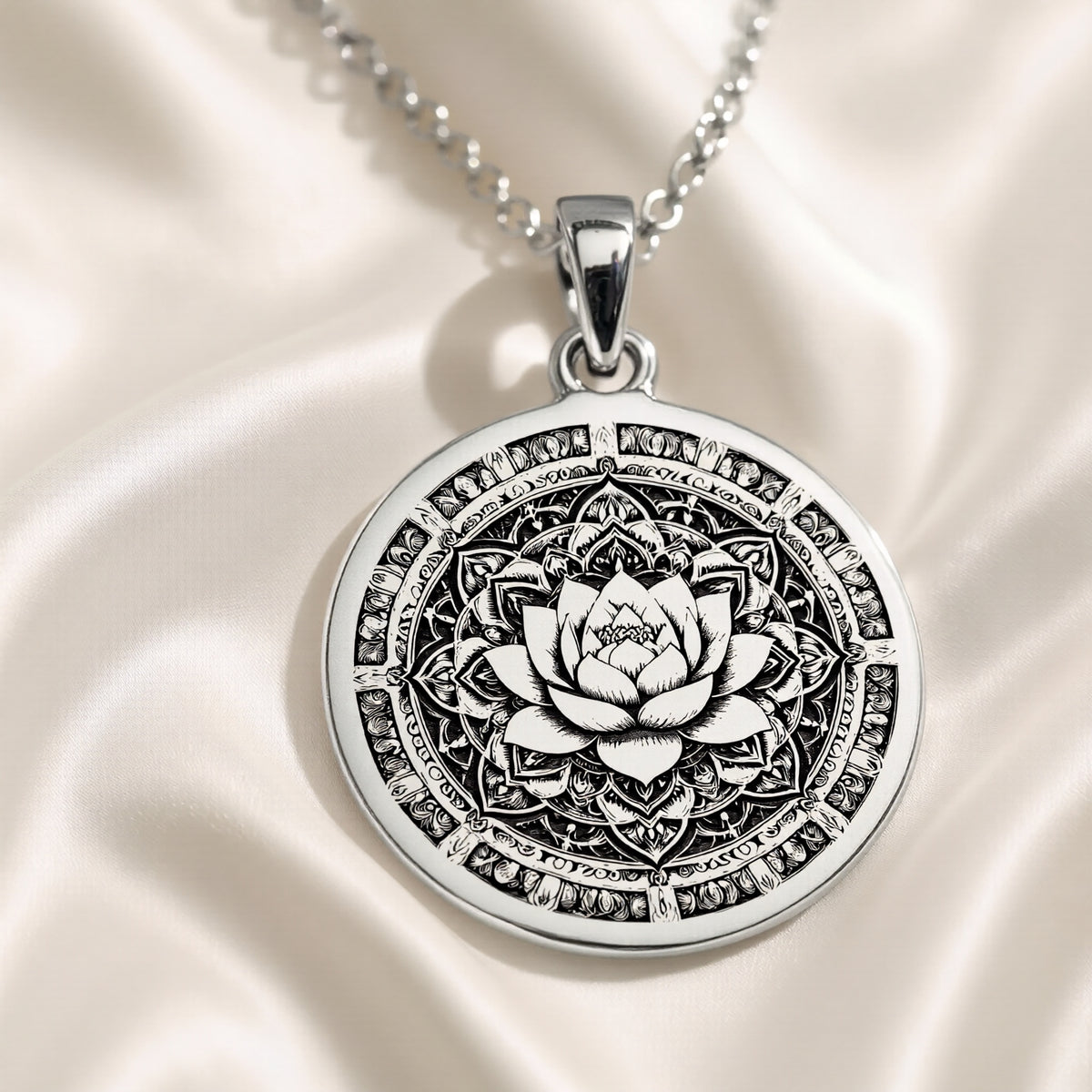 Silver pendant featuring an intricate lotus mandala design with a detailed surface finish. The pendant is attached to a delicate chain, viewed from above