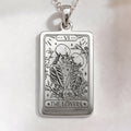 Lover Tarot Necklace pendant in sterling silver. Rectangular medallion engraved with two kissing skeletons, floral border and Roman numeral VI.