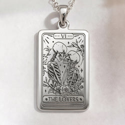 Lover Tarot Necklace pendant in sterling silver. Rectangular medallion engraved with two kissing skeletons, floral border and Roman numeral VI.