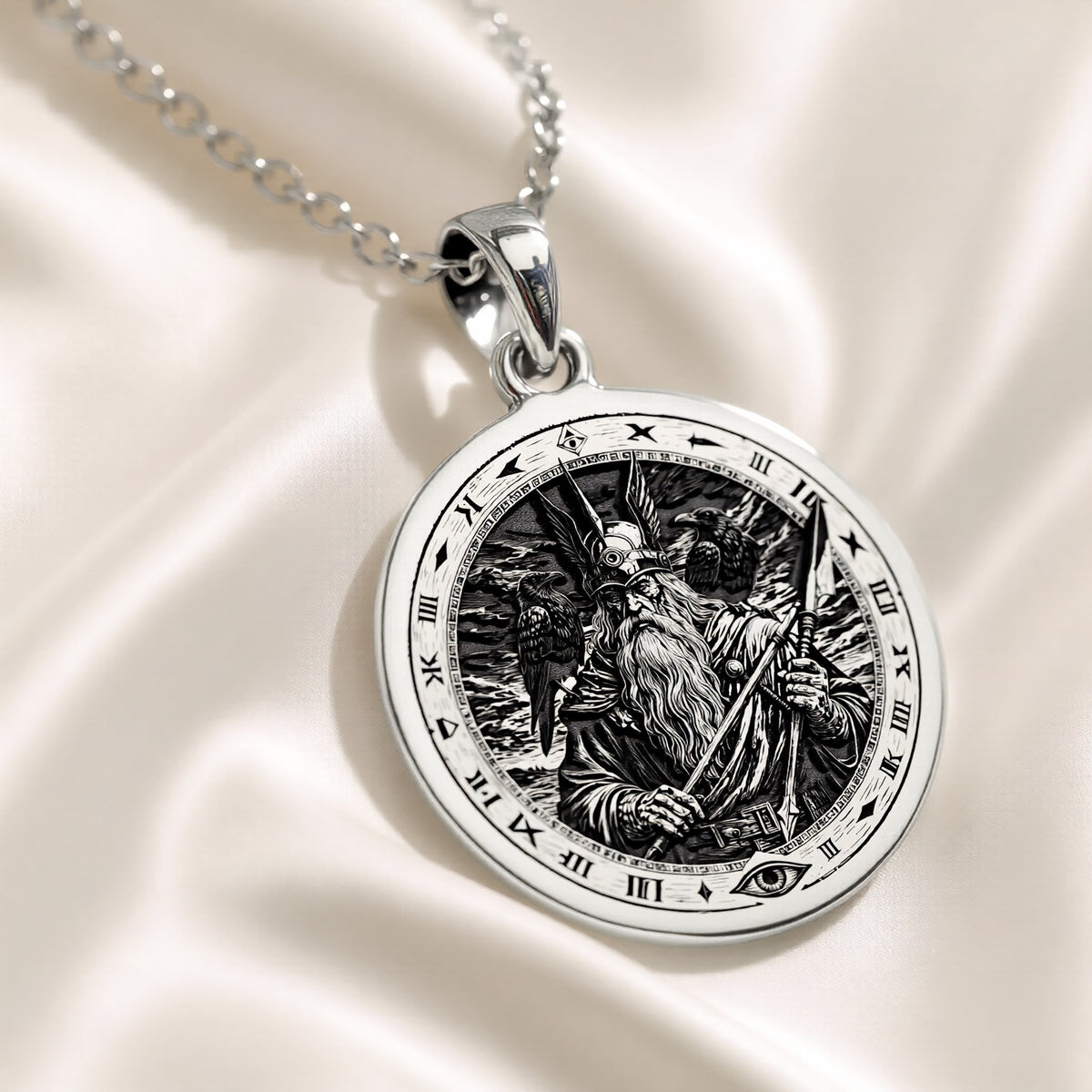 Silver pendant featuring an intricate Odin Allfather Viking motif with a detailed surface finish. The pendant is displayed on a delicate chain, viewed from a slight angle against a dark green velvet background
