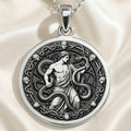Silver pendant necklace featuring a detailed circular design of a male figure entwined by a serpent, depicting an Ophiuchus or Asclepius motif. The metal has a polished finish and is displayed on a fine chain