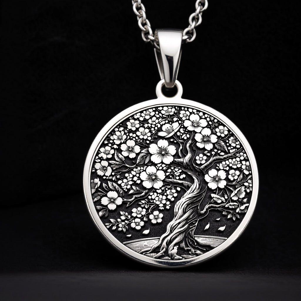 Sakura Tree Pendant in sterling silver showing the front engraving of a blooming cherry blossom tree with falling petals.