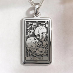 Skull Lovers Tarot Necklace rectangular pendant in sterling silver, front view of The Lovers tarot card featuring two kissing skulls framed by flowers.