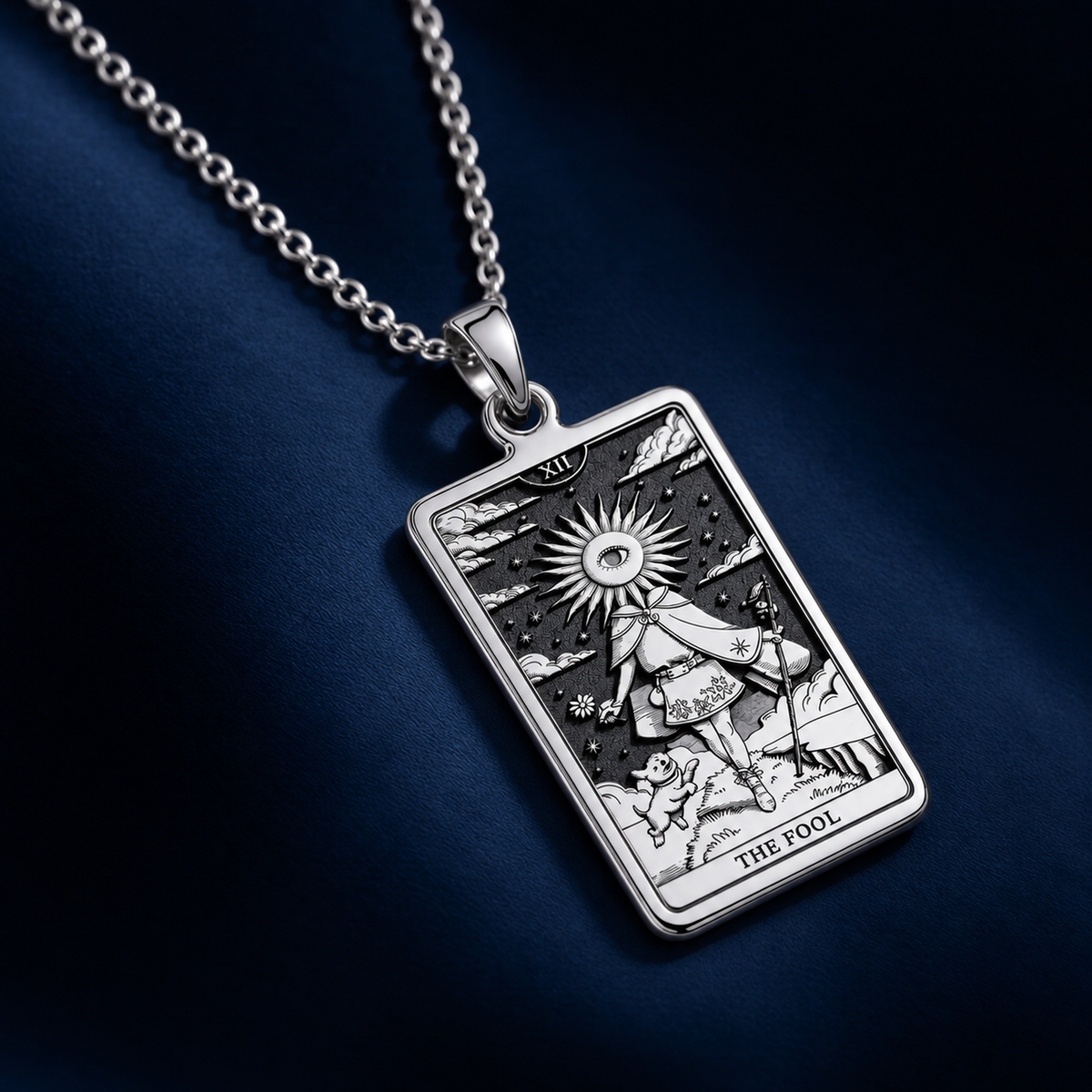 Silver tarot card charm featuring a design of The Fool, shown from a top-down view. It is a small pendant with a smooth surface finish.