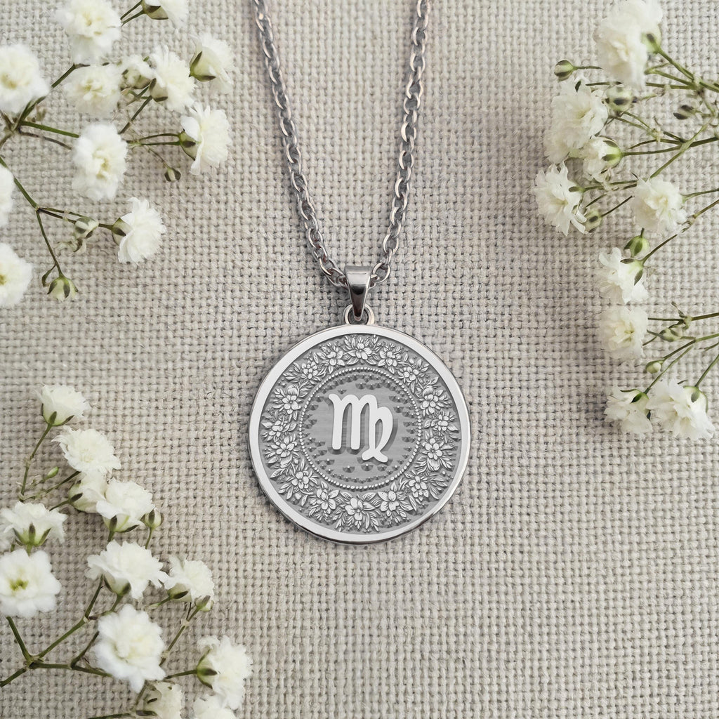 Sterling Silver Virgo Pendant with a detailed floral wreath design. Handcrafted silver coin charm featuring the zodiac maiden sign and ornate flower elements. Astrology jewelry celebrating celestial wisdom and personal dedication.